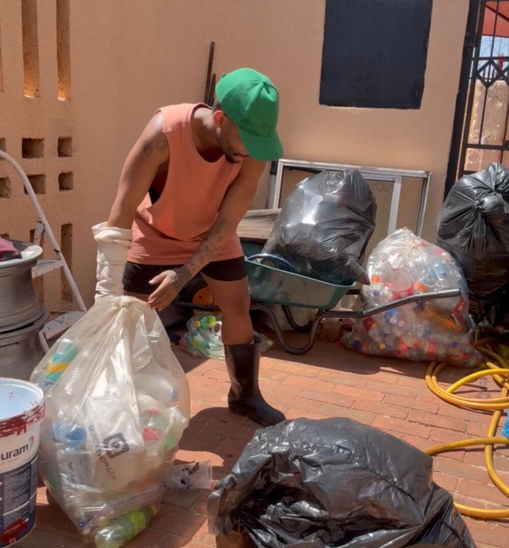A worker sorting bags of recyclable materials collected around a job